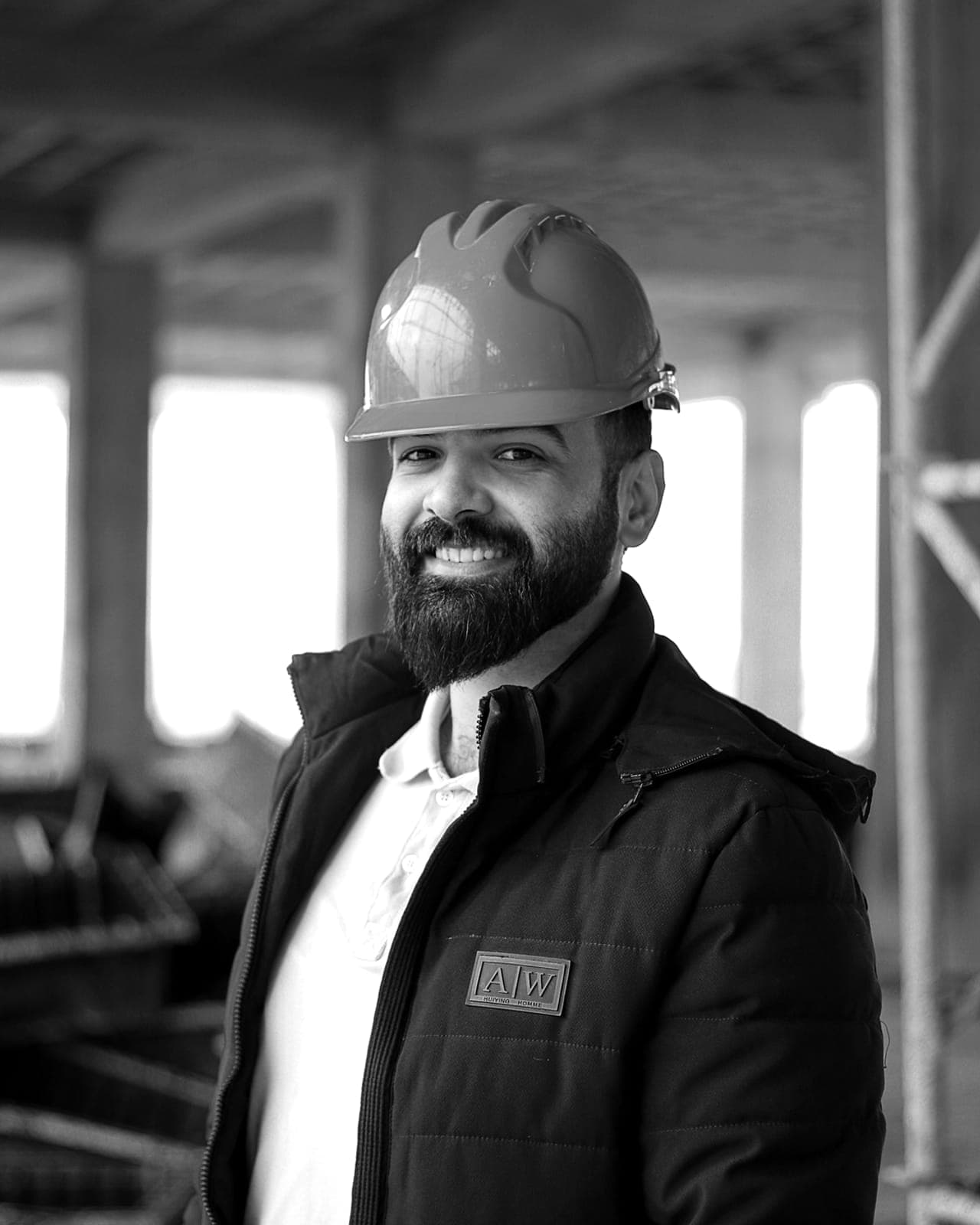 A worker in a branded jacket and hard hat on site